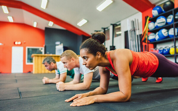 Eine Gruppe macht Planks im Fitnessstudio.
