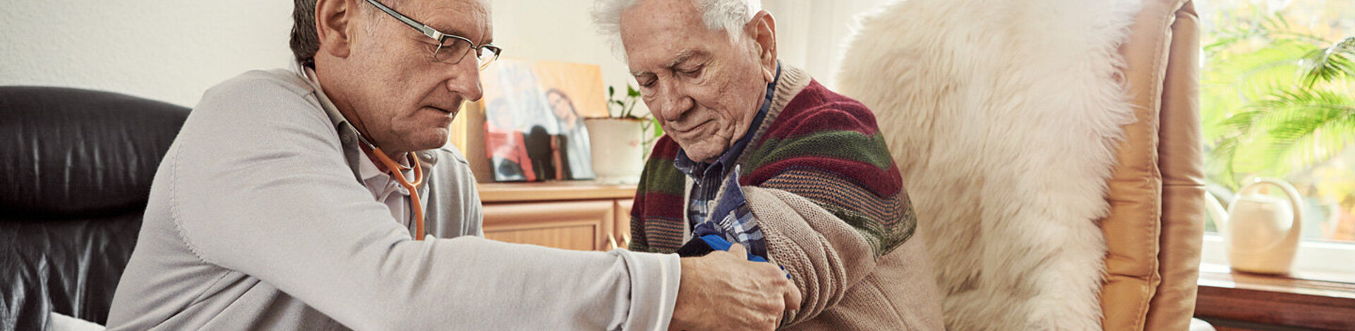 Ein Arzt misst den Blutdruck bei einem Patienten. Blutdruckmessgeräte sind wichtig, um Werte selbst zu überwachen.