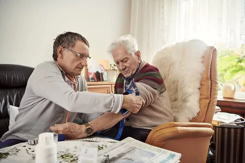 Ein Arzt misst den Blutdruck bei einem Patienten. Blutdruckmessgeräte sind wichtig, um Werte selbst zu überwachen. 