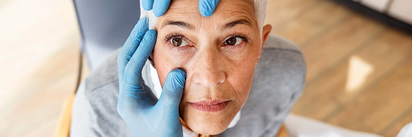 Augenarzt untersucht eine Frau, die unter Netzhautablösung leidet.