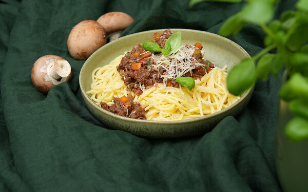 Spaghetti mit würziger Bolognese-Soße aus Pilzen auf einem grünen Keramikteller, gekocht von Felicitas Then.