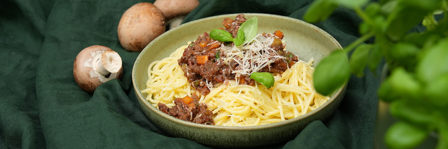Spaghetti mit würziger Bolognese-Soße aus Pilzen auf einem grünen Keramikteller, gekocht von Felicitas Then.
