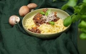 Spaghetti mit würziger Bolognese-Soße aus Pilzen auf einem grünen Keramikteller, gekocht von Felicitas Then.