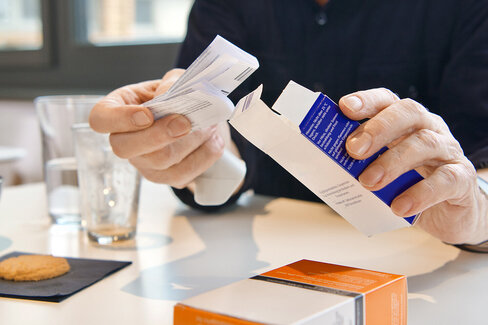 Ein Patient liest den Beipackzettel eines Medikaments. Wer mehrere Arzneimittel benötigt, profitiert von einem Medikationsplan.