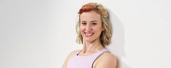 Natalia Cichos-Terrero steht in sportlicher Kleidung mit dem Rücken an eine Wand gelehnt.