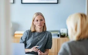 Eine Mitarbeiterin des Sozialen Dienstes der AOK im Gespräch mit einer Selbsthilfe-Interessierten.