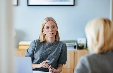 Eine Mitarbeiterin des Sozialen Dienstes der AOK im Gespräch mit einer Selbsthilfe-Interessierten.