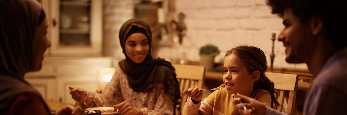 Eine junge muslimische Familie bricht nach Sonnenuntergang ihr Fasten im Ramadan.