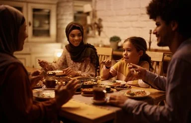 Eine junge muslimische Familie bricht nach Sonnenuntergang ihr Fasten im Ramadan.