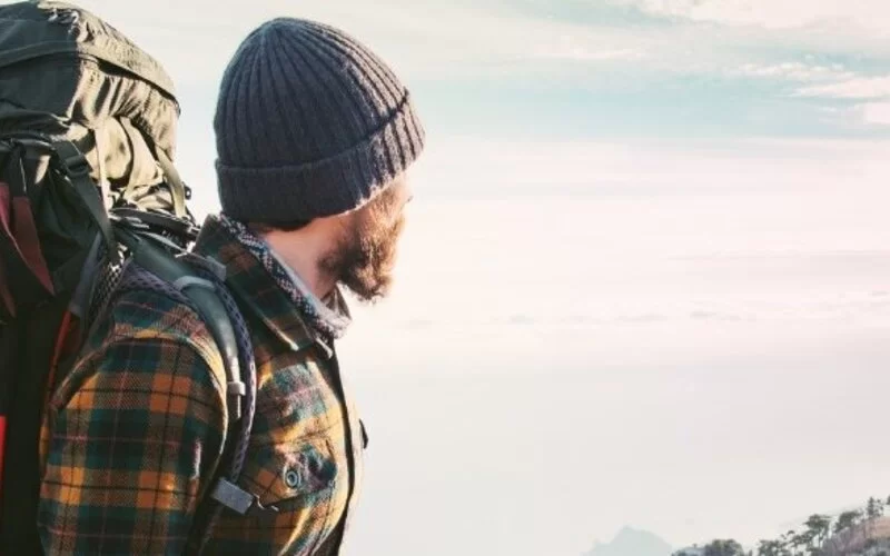  Ein Backpacking-Tourist genießt auf einem Berggipfel die Aussicht
