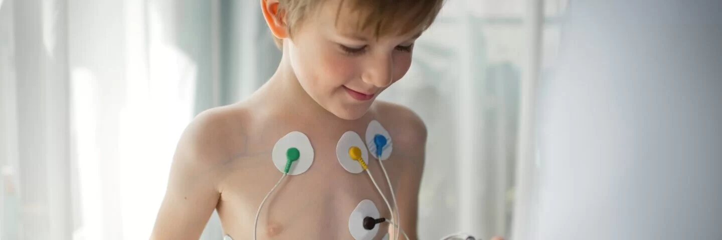 Ein Arzt stellt einen EKG-Holter-Monitor für ein Kind ein, um seine Herzgesundheit zu überprüfen.