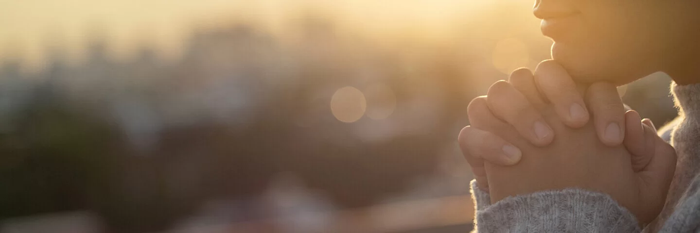 Eine Frau hat die Hände gefaltet und betet. Beim Thema Organspende sollten auch religiöse Aspekte betrachtet werden.