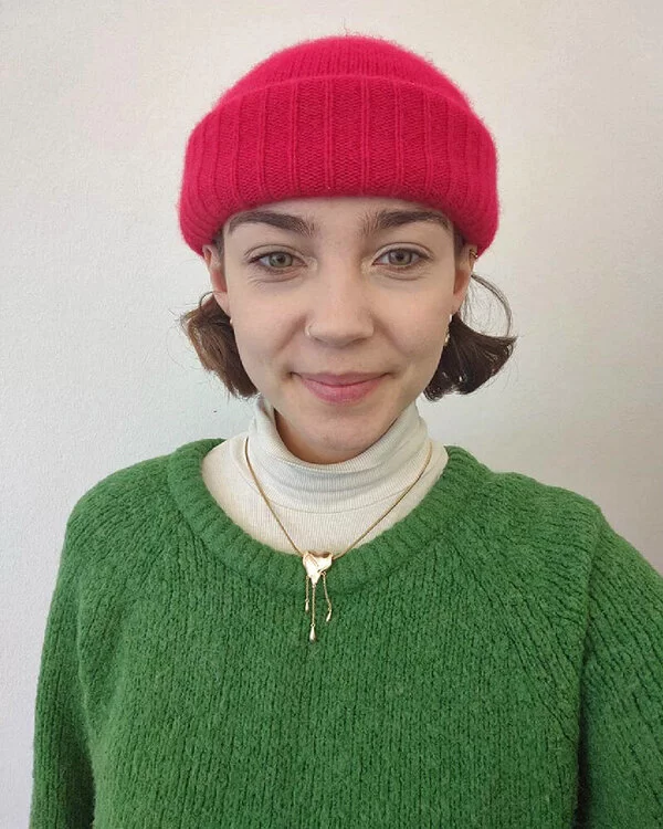 Alina Doval mit roter Mütze und grünem Pullover