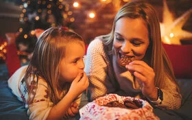 Mutter und Tochter essen achtsam Kekse.