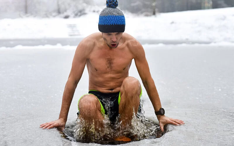 Junger Mann versucht sich im Eisbaden.