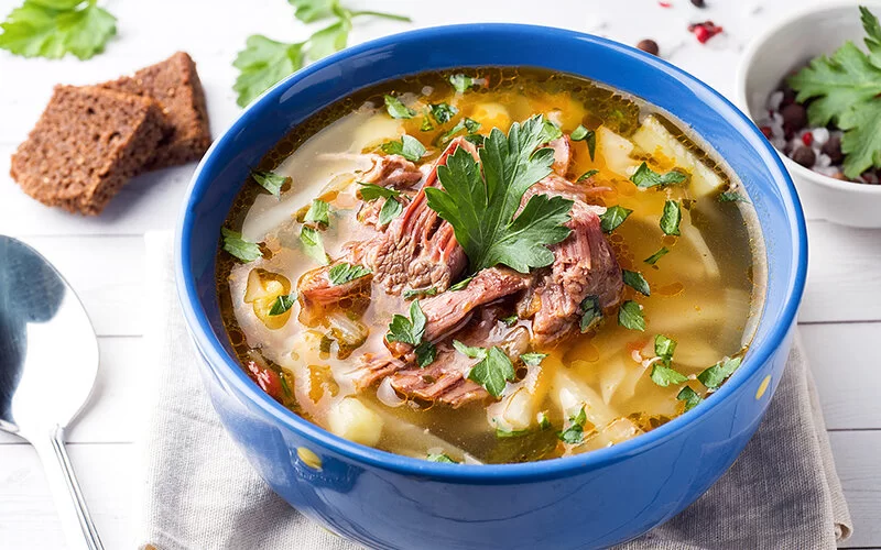 Eine traditionelle Kohlsuppe ist auf einem Tisch angerichtet.