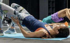 Frau macht eine Rückenübung im Fitnessstudio.