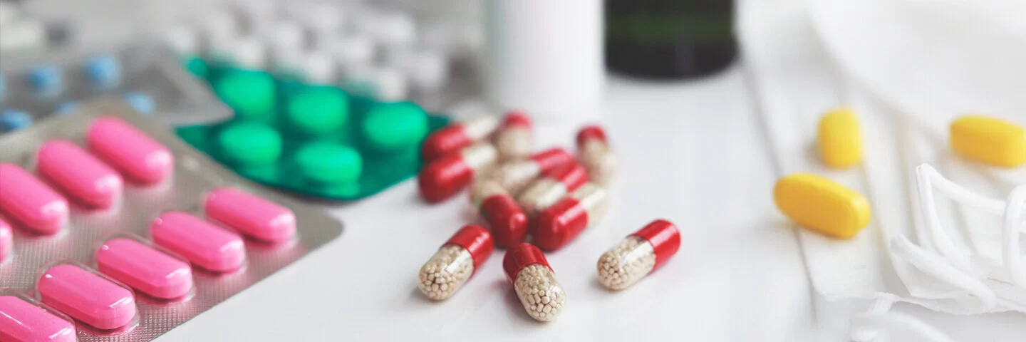 Haufen von medizinischen Pillen in weiß, rot und anderen Farben.