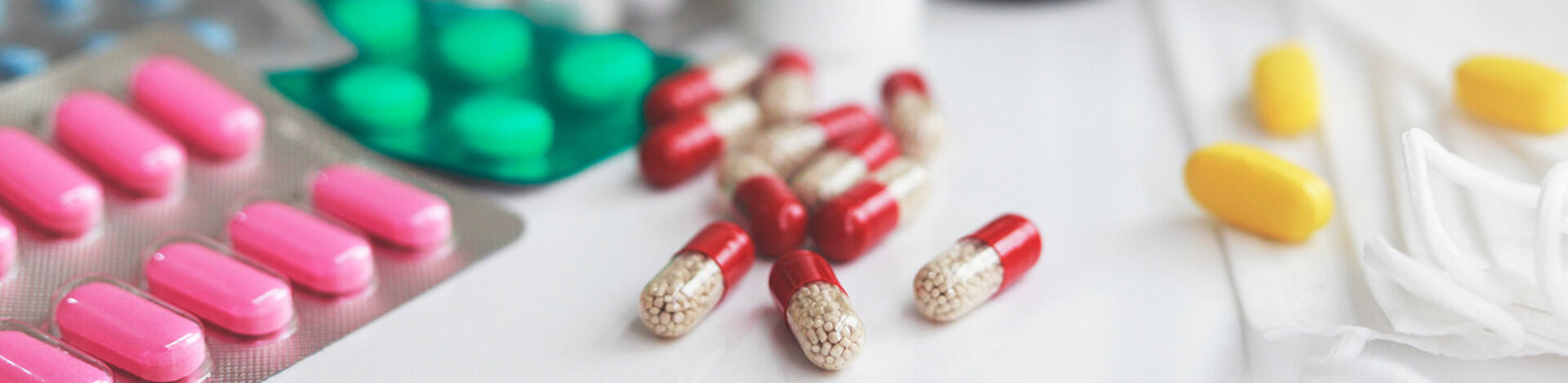 Haufen von medizinischen Pillen in weiß, rot und anderen Farben.