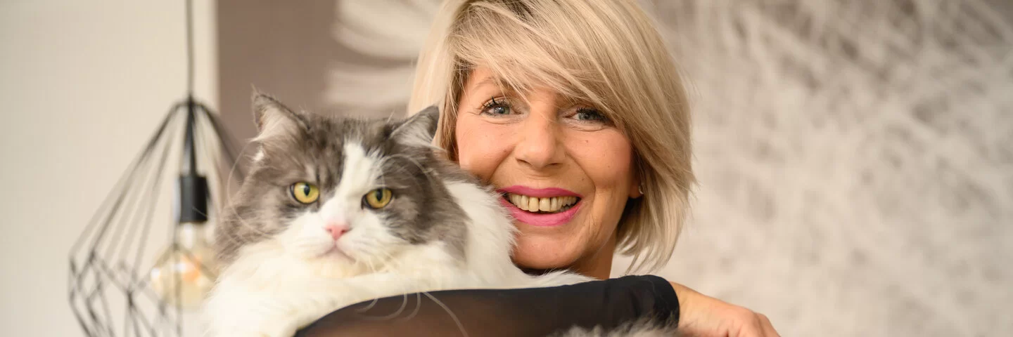 Auf dem Bild ist Elke Zellin zu sehen mit einer Katze auf dem Arm. 