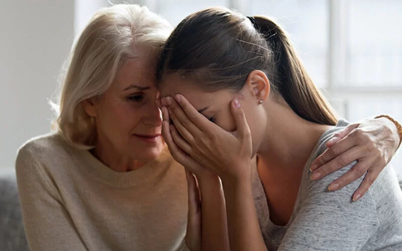 Eine Mutter tröstet Ihre Tochter mit Depressionen.