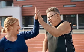 Frau und Mann auf einem Sportplatz.