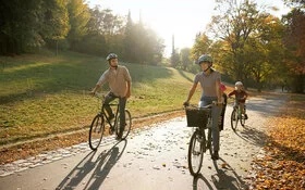 Ein Paar und ihre zwei Kinder fahren Fahrrad im Wald.