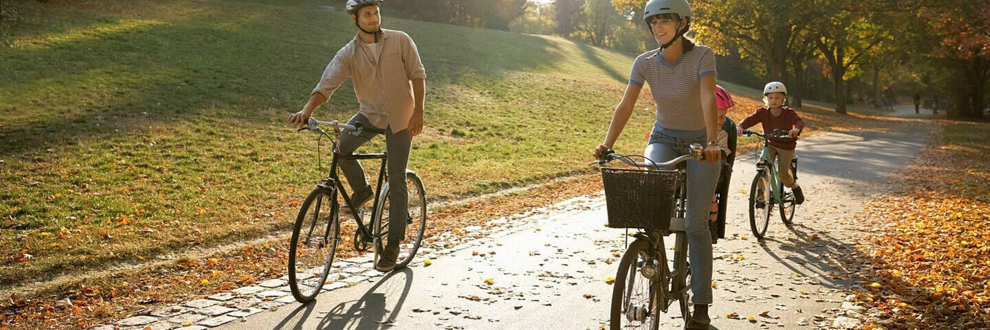 Ein Paar und ihre zwei Kinder fahren Fahrrad im Wald.