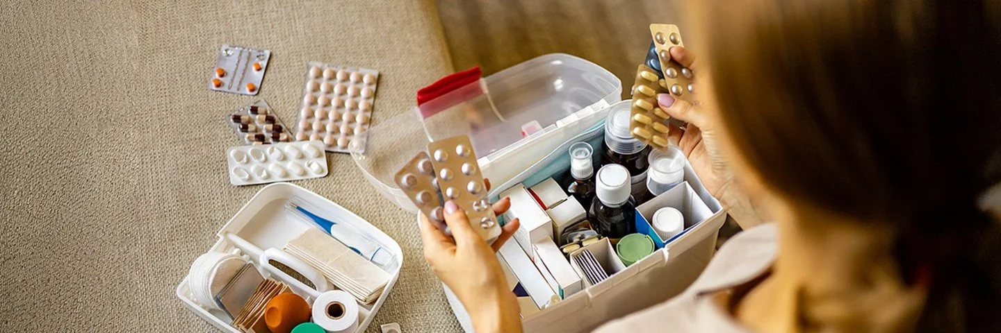 Eine Frau sortiert Ihre Medikamente in Ihrer Hausapotheke.