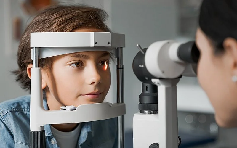 Ein Junge mit Sehschwäche ist beim Augenarzt, wo seine Augen und Sehstärke vermessen werden.