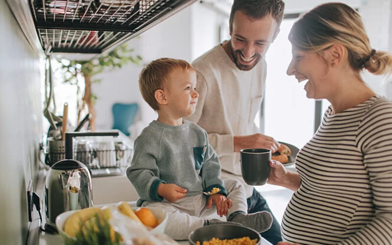 Familie in der Küche ist glücklich, weil sie zurück in die gesetzliche Krankenversicherung gewechselt ist.