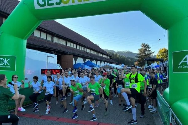 Eine große Gruppe Menschen macht sich vor einem Lauf warm
