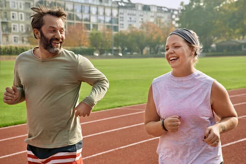 Eine Frau und ein Mann joggen und verbessern ihre Fitness.