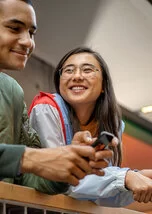 Ein junger Mann und eine junge Frau lachen sich an.