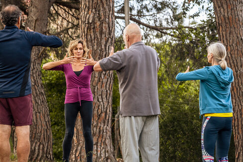 Vier Erwachsene trainieren im Freien. Vorsorgekuren helfen, fit und gesund zu bleiben.