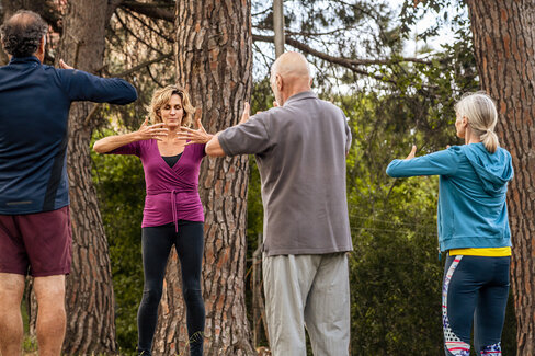 Vier Erwachsene trainieren im Freien. Vorsorgekuren helfen, fit und gesund zu bleiben.