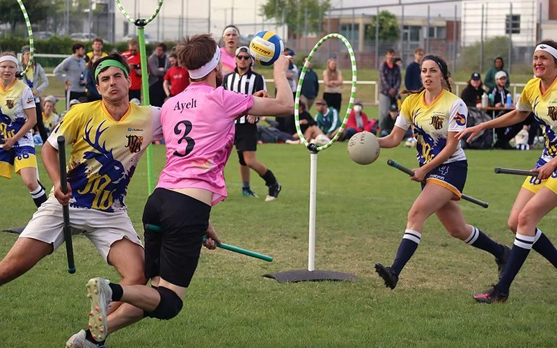 Ein Quadball-Spieler zielt auf die Ringe, das gegnerische Team verteidigt.