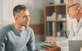 Ein junger Mann spricht mit seinem Arzt über Hodenkrebs.
