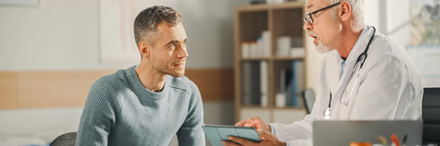 Ein junger Mann spricht mit seinem Arzt über Hodenkrebs.