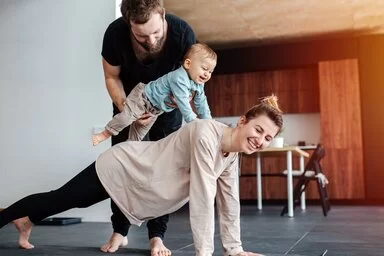 Papa legt Baby auf den Rücken der Mama. Starke Familie.