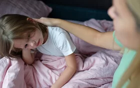 Eine Frau tröstet ein Kind mit Schlafproblemen.