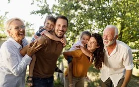 Eine Mehrgenerationenfamilie geht im Grünen spazieren.