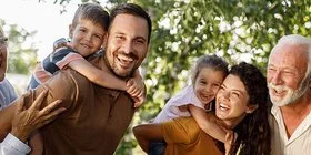 Eine Mehrgenerationenfamilie geht im Grünen spazieren.