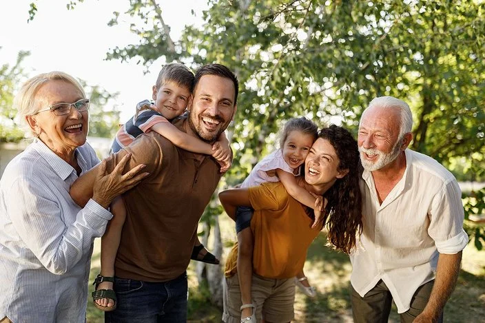 Eine Mehrgenerationenfamilie geht im Grünen spazieren.