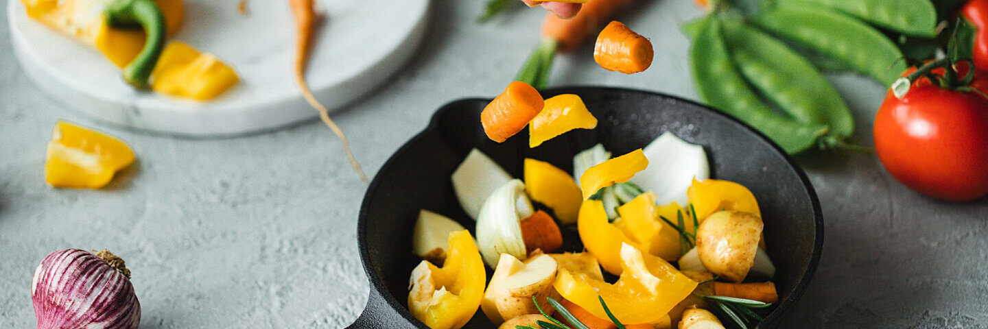 Obst und Gemüse liegen auf einem Tisch mit einem Schneidebrett.