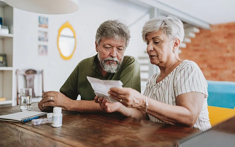 Ein Mann und eine Frau lesen die Packungsbeilage eines Medikaments.