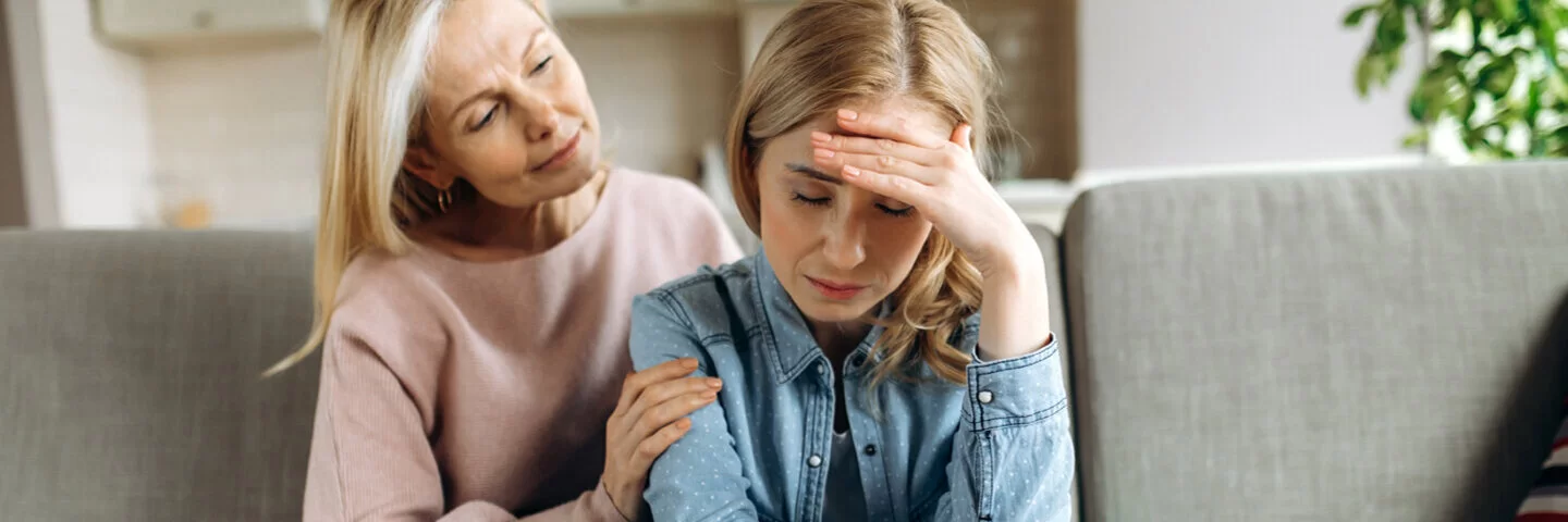 Eine ältere Frau tröstet eine junge Frau mit Depressionen.