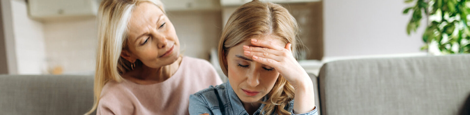 Eine ältere Frau tröstet eine junge Frau mit Depressionen.