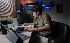 Junger Mann arbeitet bis spät in die Nacht am Rechner – ist er ein Workaholic?