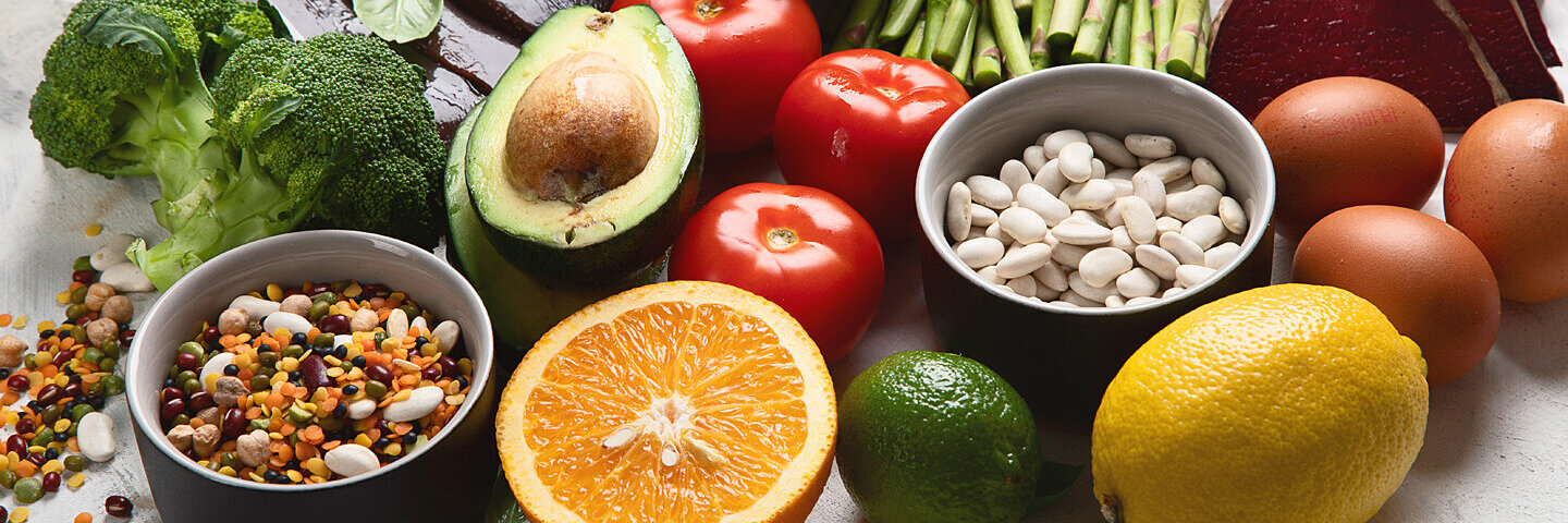 Einige Lebensmittel mit einem hohen Gehalt an Folsäure (Vitamin B9) auf einem Tisch.